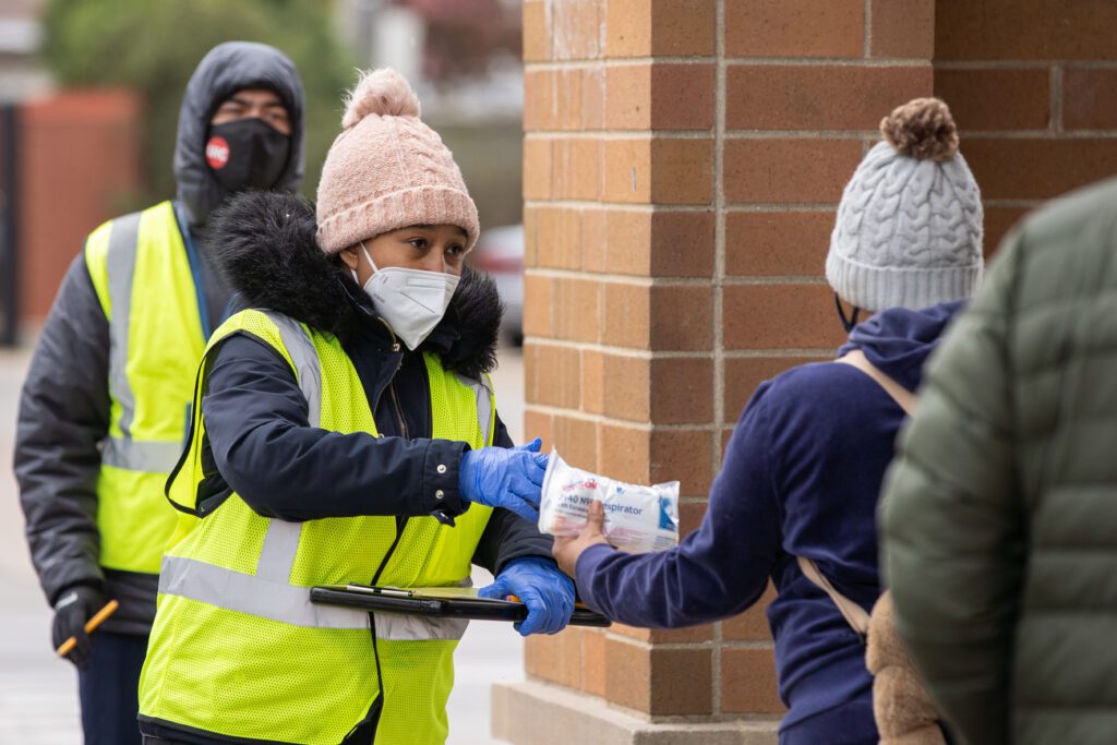 A COVID-19 outreach specialist hands out masks